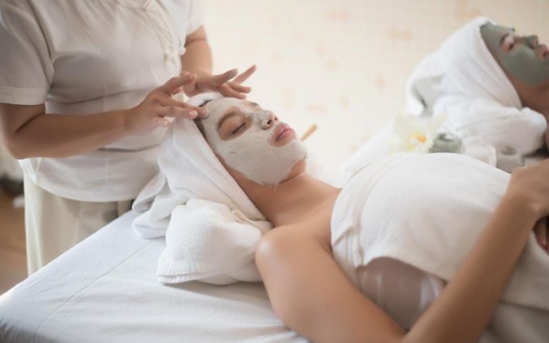 Woman receiving face mask at spa.