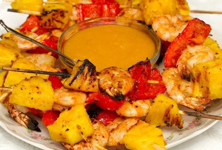 Pineapple and shrimp skewers with sauce.