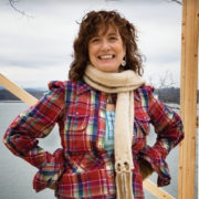 Woman wearing red flannel standing on a construction site at the lake.